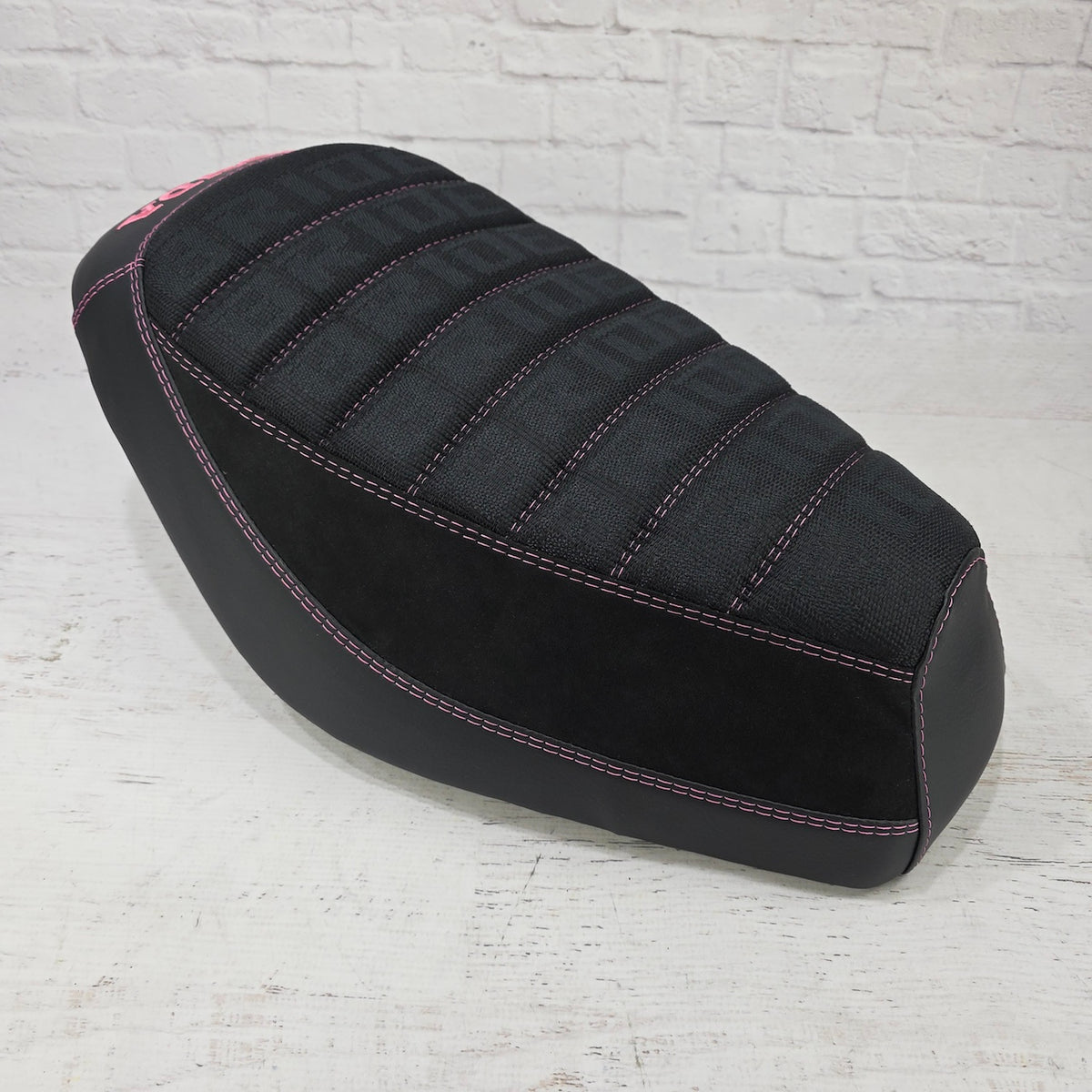 front view Honda Dio 1 & 2 Seat cover with Black Bride deck, Alcantara sides and matte black, trimmed with pink stitching and a pink Honda logo. Handmade by Cheeky Seats
