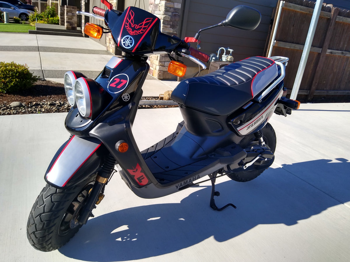 Tuck-and-roll seat cover fitted to a customized Yamaha Zuma 50, coordinating black, silver and red details, handmade by Cheeky Seats.