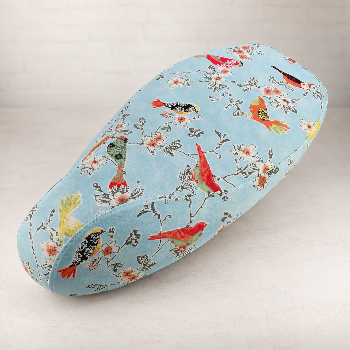 Songbirds Vespa seat cover with birds perched among flowering branches on a pale blue background, handmade by Cheeky Seats.