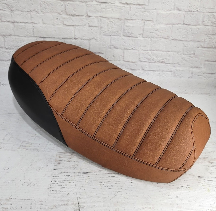 Front three-quarter view of an Anti slip distressed Slickrock brown Yamaha Zuma II BWS 49/50 Prebug tuck-and-roll seat cover with black rear panels, handmade by Cheeky Seats