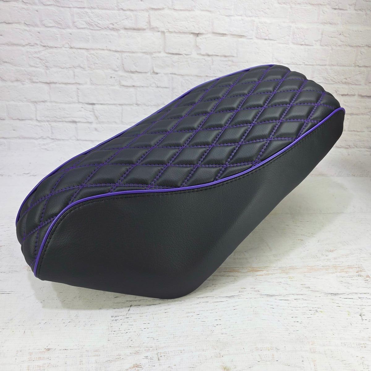 Side view of a Genuine Roughhouse 50 Seat with a double diamond seat cover with purple piping and stitching, handmade by Cheeky Seats 