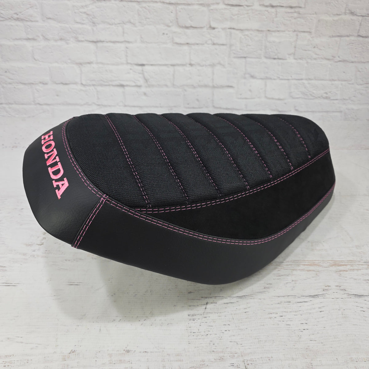 Honda Dio 1 & 2 Seat cover with Black Bride deck, Alcantara sides and matte black, trimmed with pink stitching and a pink Honda logo.  Handmade by Cheeky Seats