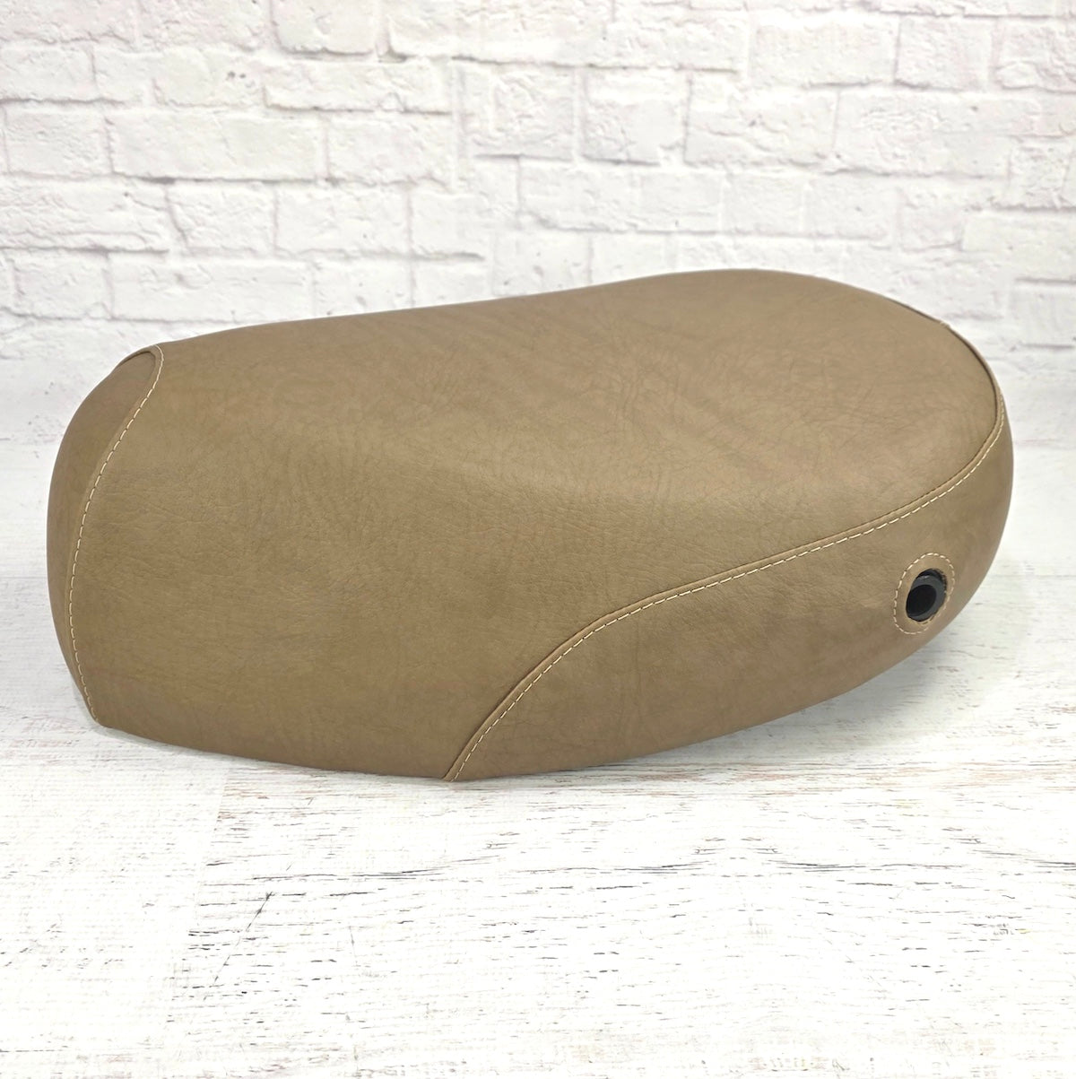 Side profile of a café tan Kymco People 50 seat cover with matching tan stitching and a reinforced lock-opening grommet, handmade by Cheeky Seats