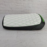 White diamond-stitched Maddog seat cover with green contrast stitching, black side panels, and green embroidery, handmade by Cheeky Seats