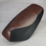 Brown and Black Yamaha Zuma 50 seat cover with a smooth vintage-brown center and tailored black side panels, handmade by Cheeky Seats.