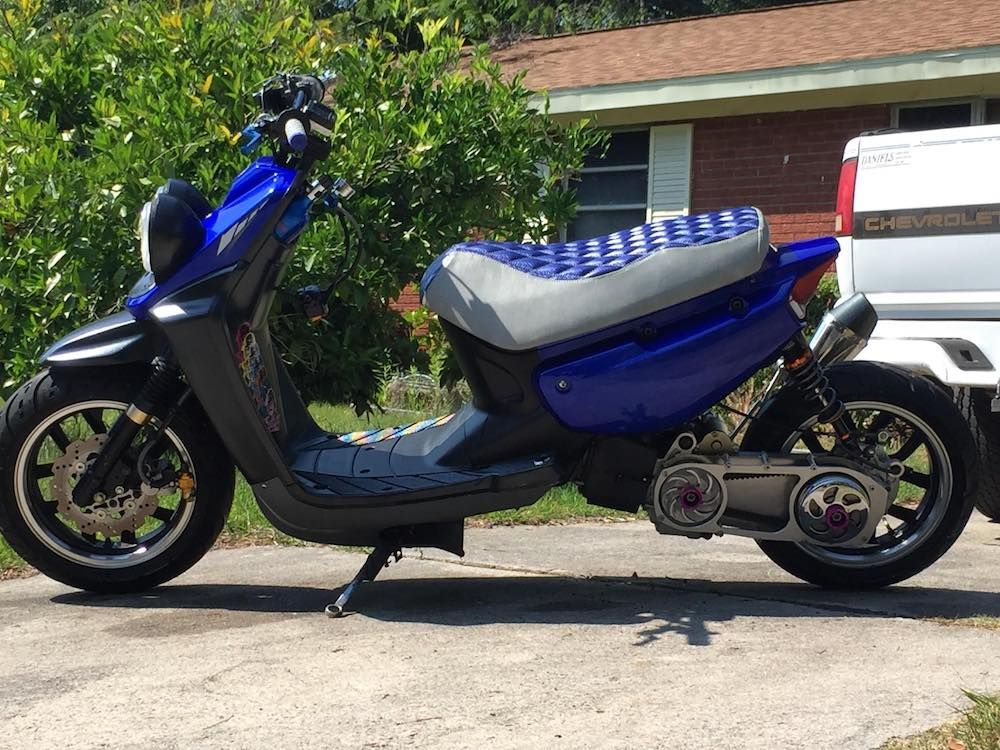 Blue and Gray Double Diamond seat cover fitted to a blue Yamaha Zuma 50, showing the tailored two-tone profile, handmade by Cheeky Seats.