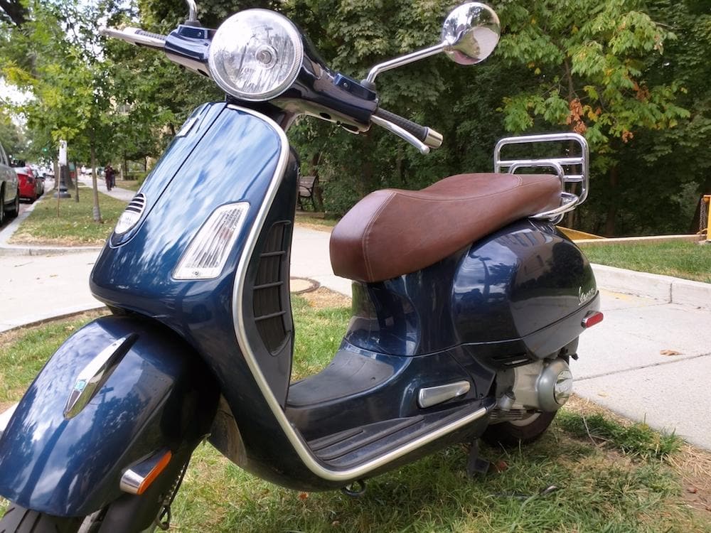 Vespa GTS whiskey brown seat cover on blue scooter